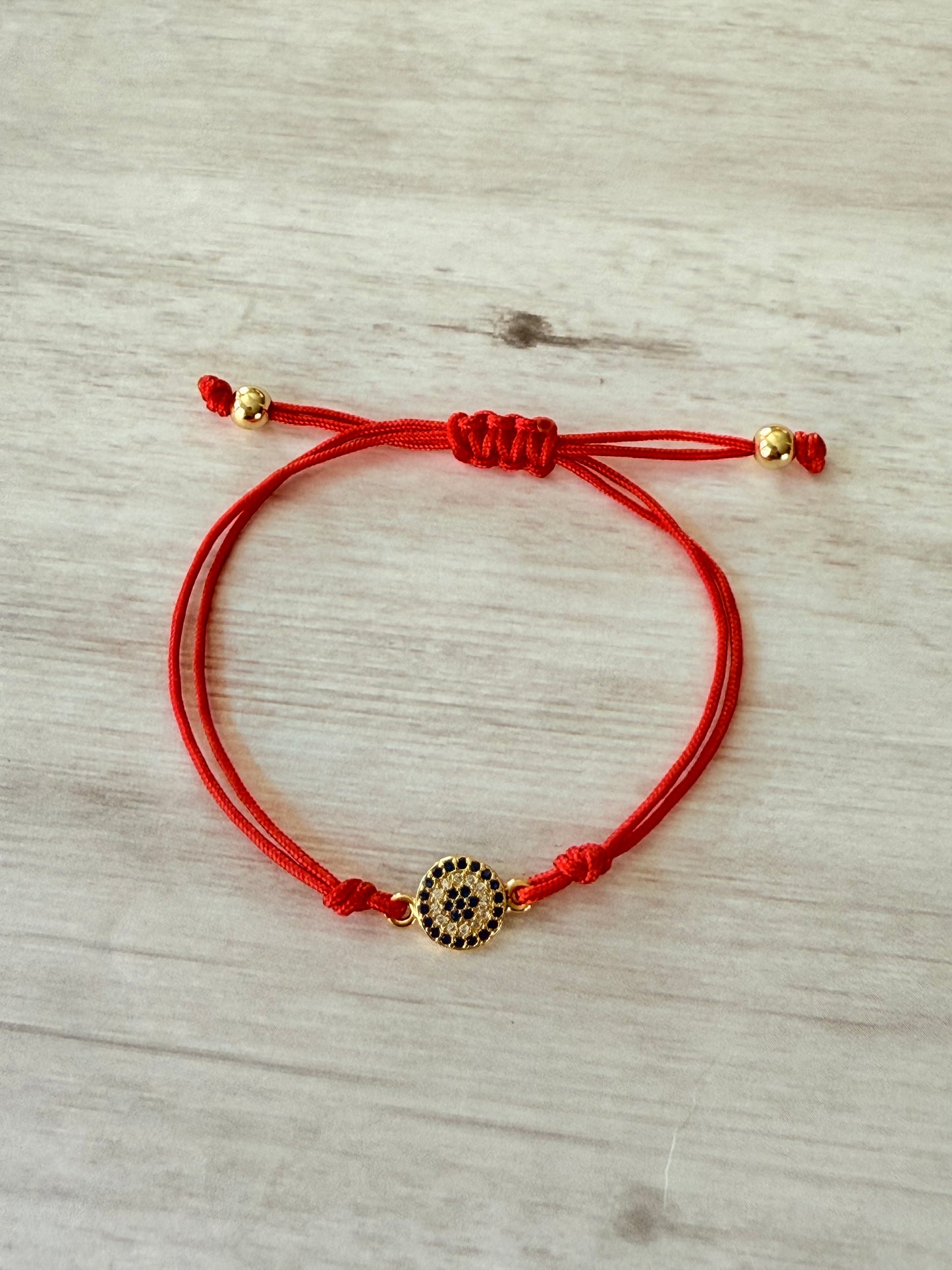 Red cord gold evil eye
