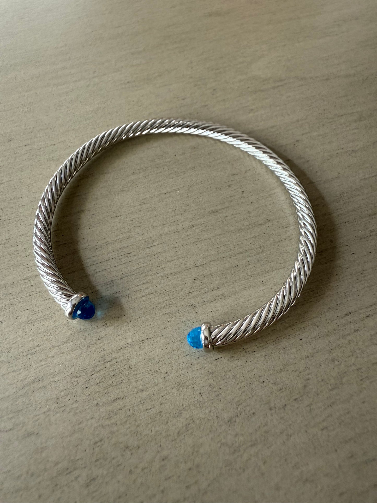 Silver twist cable cuff bracelet with blue tips